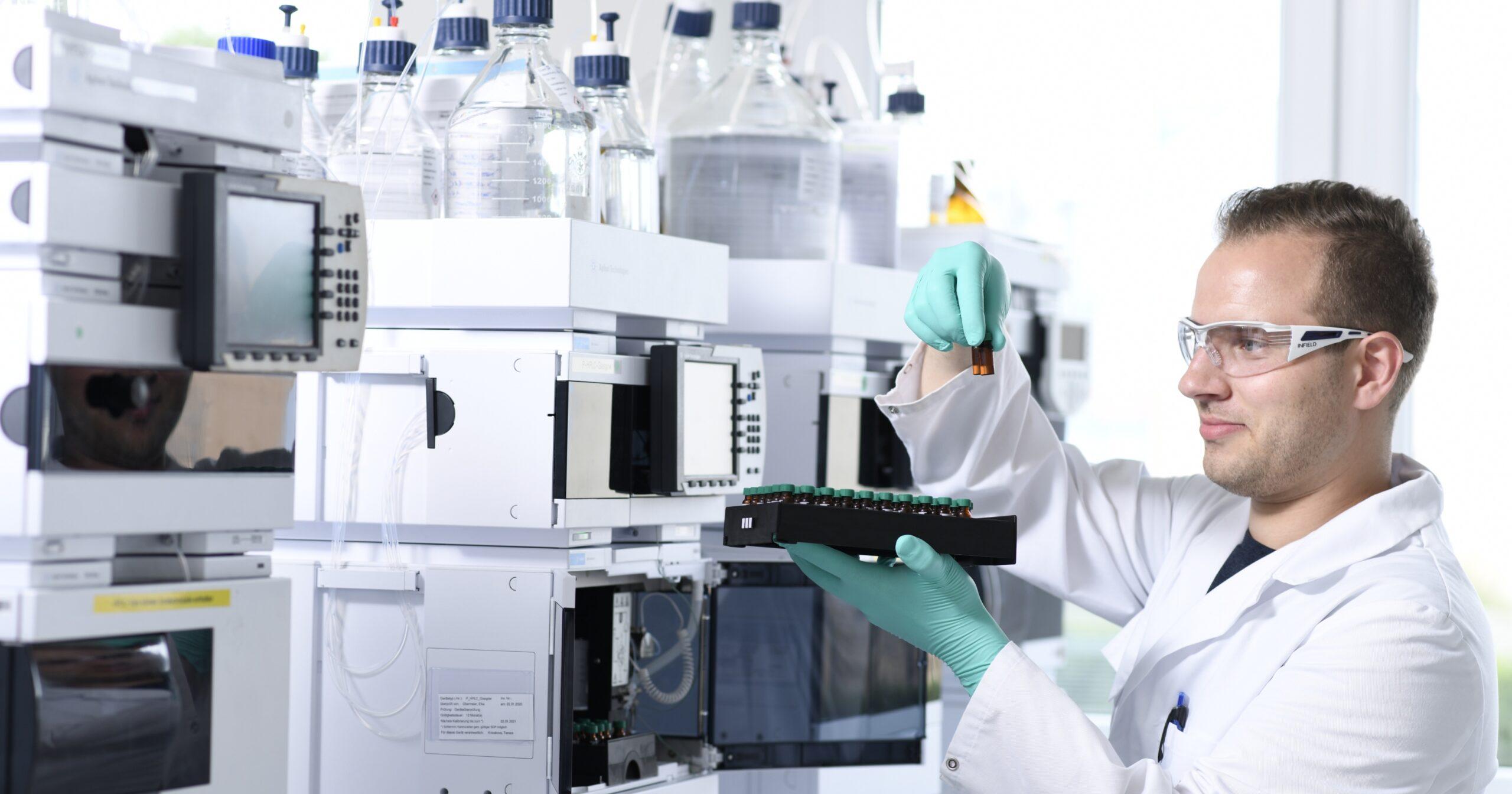 A quality-control scientist handling samples in a regulated manufacturing lab